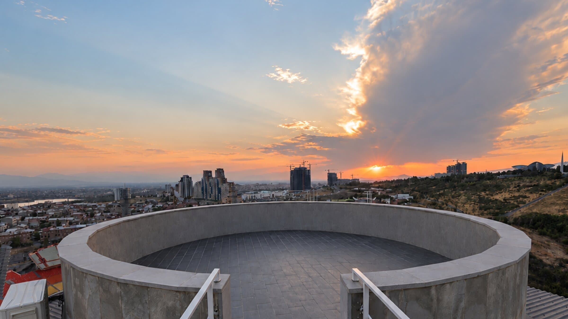 Rooftop platform under a dramatic sunset sky
