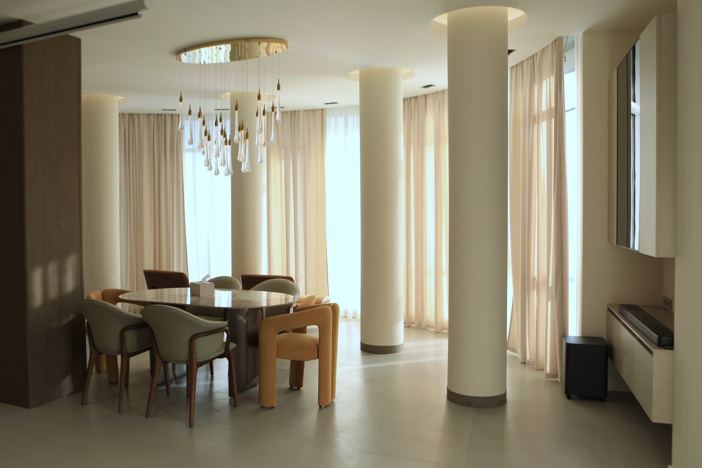 Dining area with a crystal chandelier and floor-to-ceiling curtains