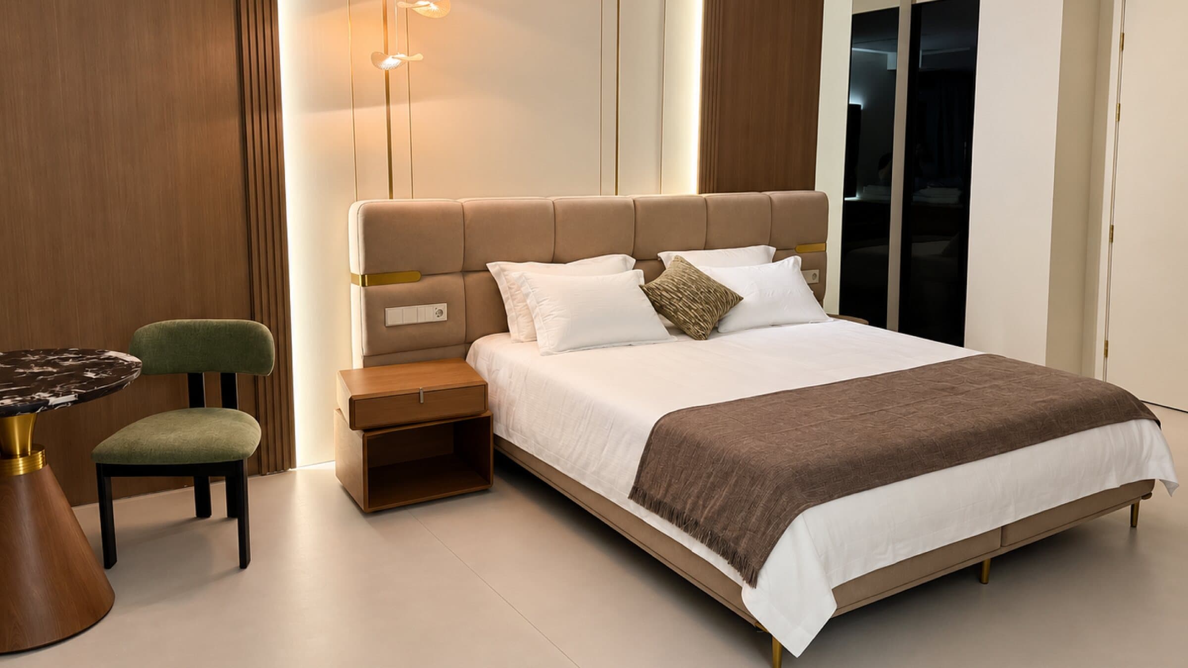 Bed with an upholstered headboard and a green chair