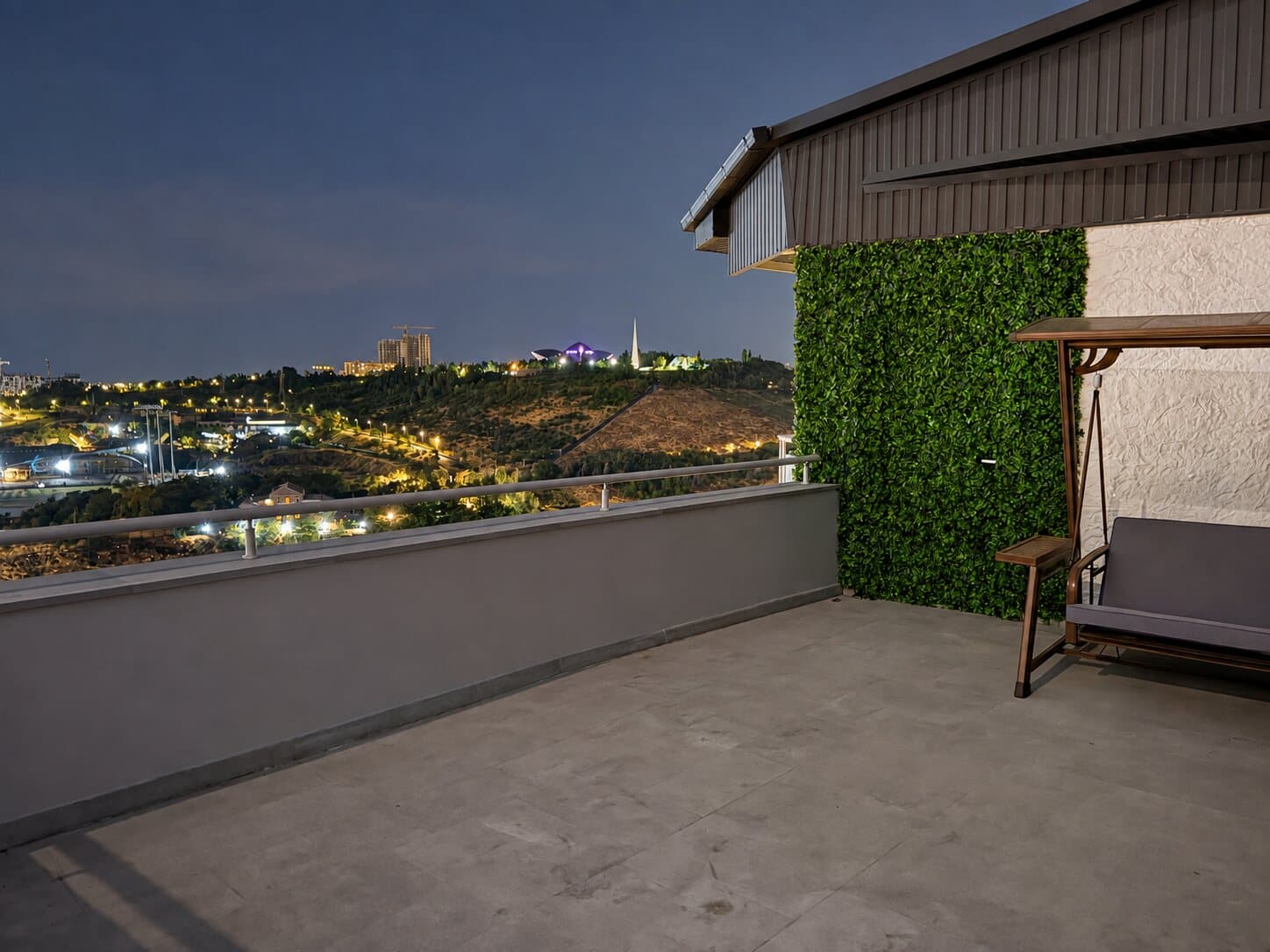 Terrace with a garden swing and a green wall