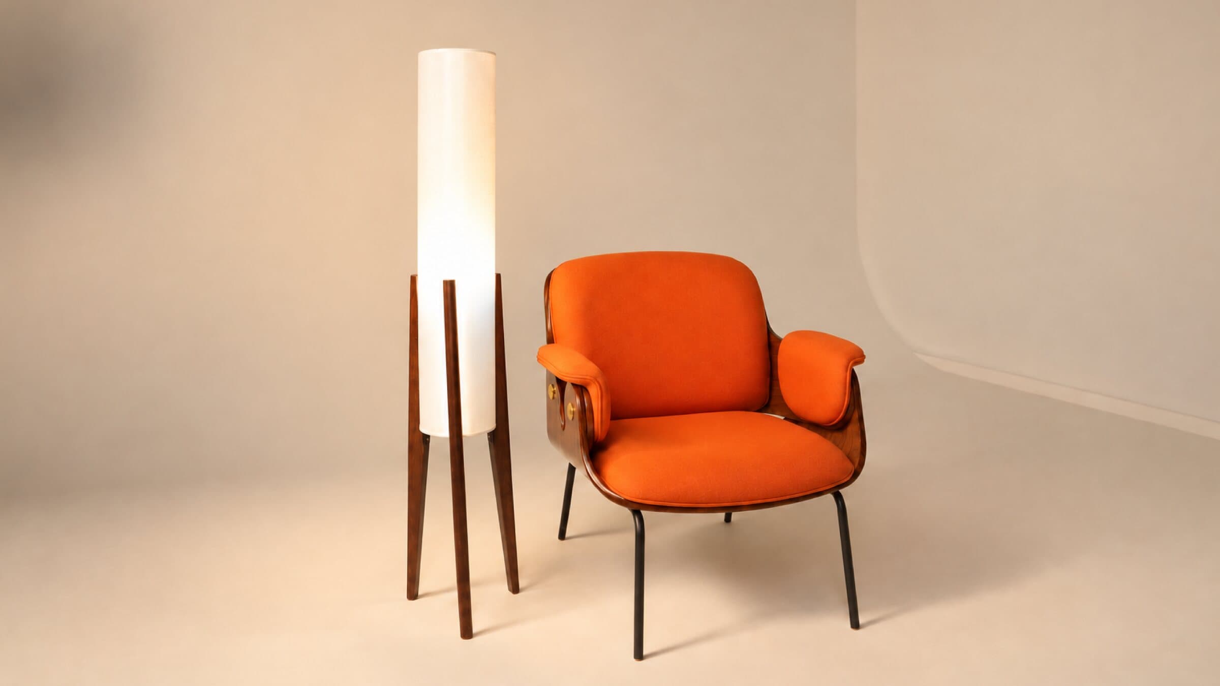 Orange armchair and tall floor lamp on a warm-toned cyclorama