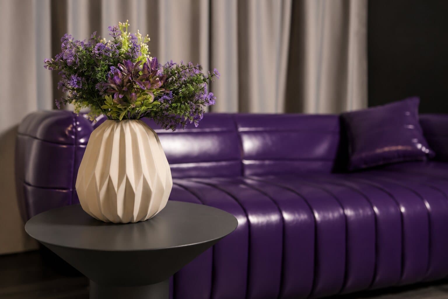 Close-up of the purple sofa with a vase of flowers
