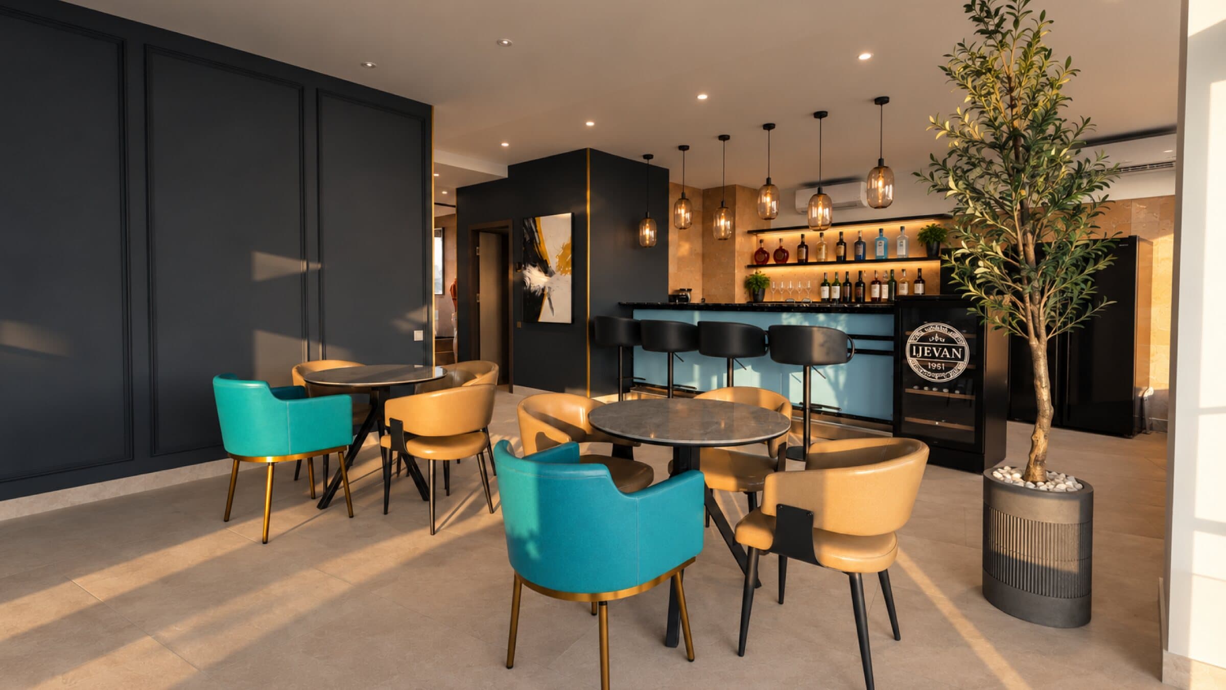 Bar and seating with teal and caramel chairs under pendant lights