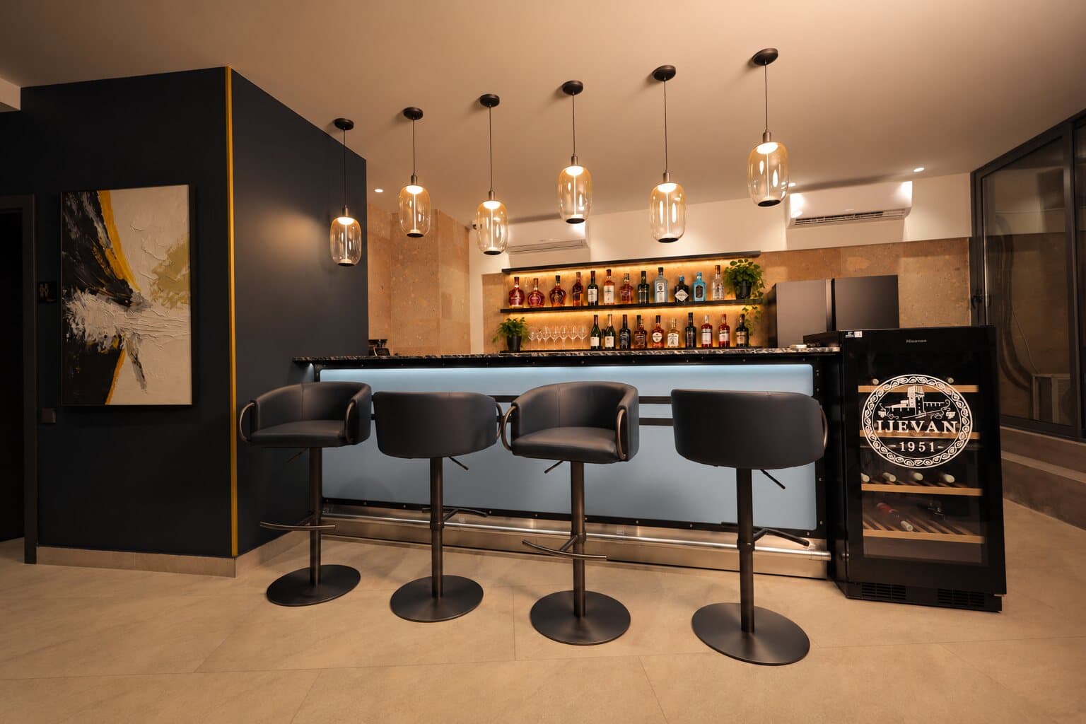Bar stools along the counter and a wine fridge